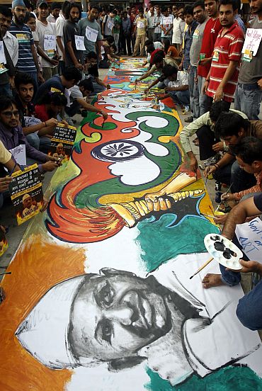 Supporters of Anna Hazare paint his sketch during a protest against corruption in Chandigarh