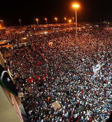 People gather near the courthouse in Benghazi August 22, 2011 to celebrate the entry of rebel fighters into Tripoli