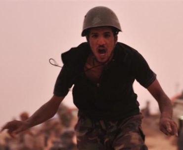 A rebel fighter runs during a shootout with forces loyal to Libya's leader Muammar Gaddafi on the outskirts of Al-Briqa, west of Ajdabiyah, July 14