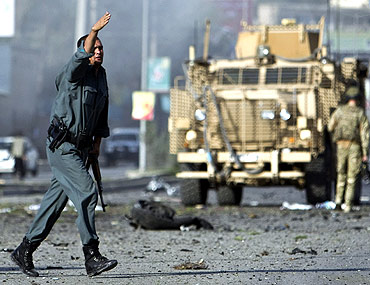 A policeman gestures during an attack on offices belonging to the British council in Kabul