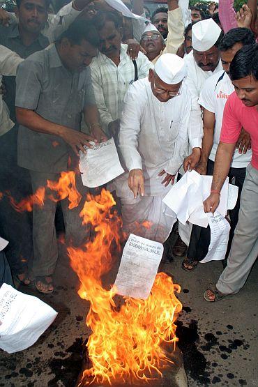 Social activist Anna Hazare burns copies of the government's Lokpal Bill