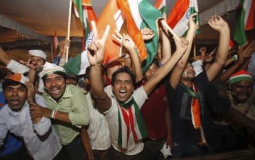 Supporters of Hazare shout pro-Hazare slogans as they celebrate after Hazare announced his decision to end his fast