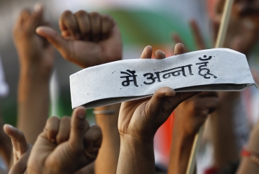 A supporter of Hazare holds a traditional Indian cap on which the words read: I am Anna