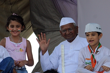 Hazare waves to crowds after breaking his fast