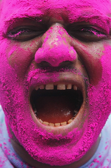A supporter of Hazare, with his face smeared in pink colour, shouts pro-Hazare slogans during the celebrations