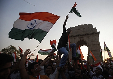 Hazare's supporters wave  national flags in front of India Gate
