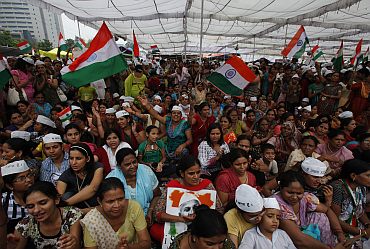 Supporters of Indian social activist Hazare wave Indian national flags at Ramlila grounds