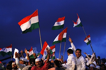 Supporters of veteran Indian social activist Anna Hazare shout slogans as they wave Indian national flags