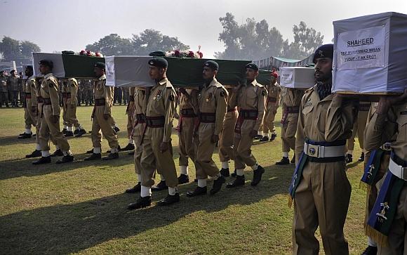 The word shaheed is written on the caskets of soldiers killed in a cross-border attack along the Pakistan-Afghan border, as their bodies are being carried for funeral prayers in Peshawar