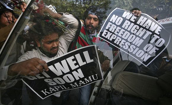 Activists in New Delhi protest against Kapil Sibal's remarks.