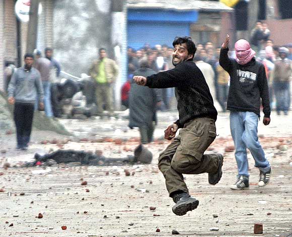 A Kashmiri protester hurls stones at Jammu and Kashmir policemen during a protest in Srinagar in 2010