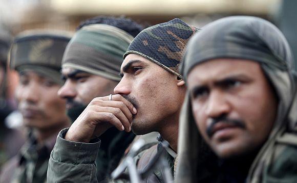 A group of Indian army soldiers rests during a gun battle with separatist militants in the village of Dadsar near Srinagar