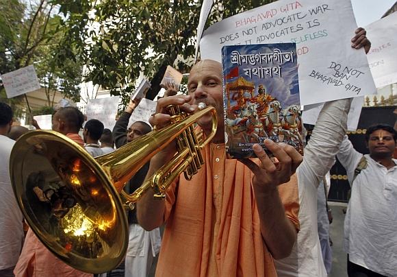 A member of the global Hare Krishna sect plays a trumpet during a protest outside the Russian consulate in Kolkata