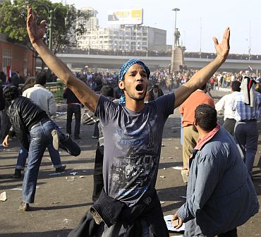 A demonstrator gestures during rioting between pro and anti-Mubarak supporters at Tahrir Square