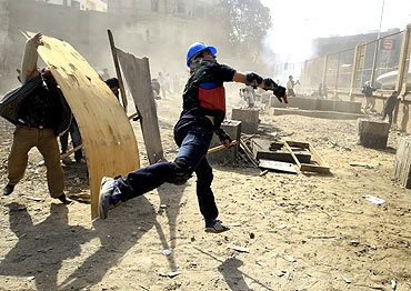 Opposition supporters throw stones at pro-Mubarak demonstrators in Tahrir Square