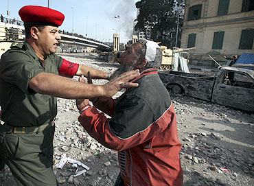 An opposition demonstrator is restrained by police in Tahrir Square