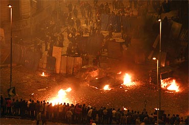 Pro-government protesters clash with anti-government protesters outside the National Museum near Tahrir square in Cairo