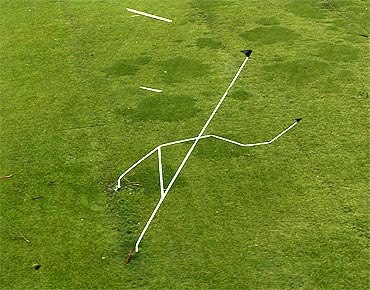 A set of rugby goal posts stand twisted by Cyclone Yasi