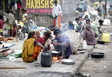 Homeless prepare their food by the roadside in Ahmedabad
