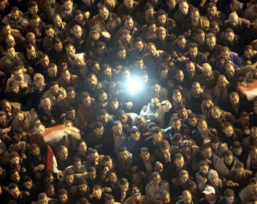 Anti-government protesters in Cairo's Tahrir Square listen as President Hosni Mubarak addresses the nation in a televised speech