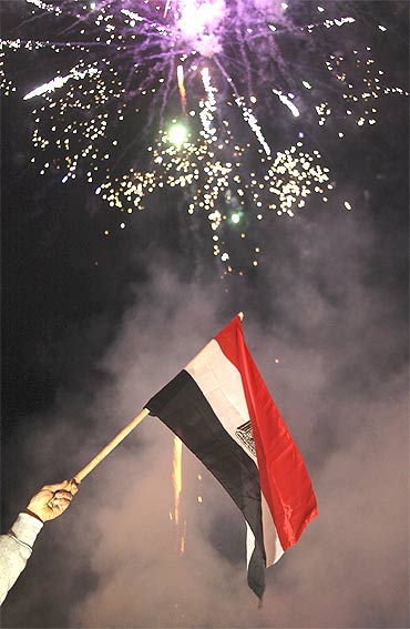 The Egyptian flag is aflutter as fireworks explode in celebration after Hosni Mubarak stepped down as Egypt president