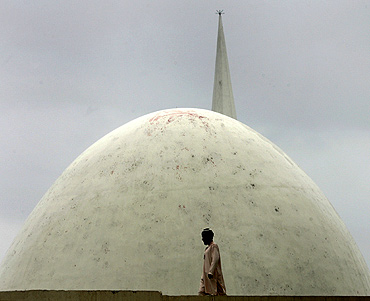 A man walks on the roof of the Red Mosque during a gathering in Islamabad to mark the first anniversary of an army raid on the complex