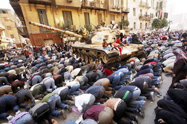 Egyptian cleric Sheikh Egyptian pro-democracy supporters pray next to an army tank during Friday prayers in Tahrir Square