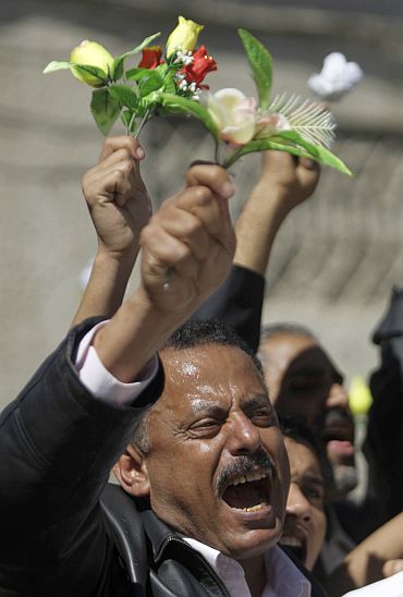 Oppn MP Ahmad Saif Hashid shouts slogans as he waves roses during an anti-government protests