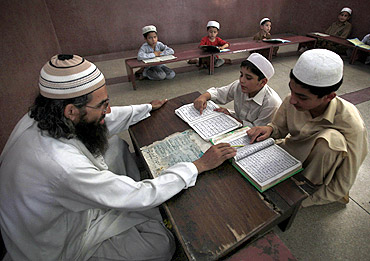 A teacher guides students in reciting verses from the Quran at a mosque in Peshawar