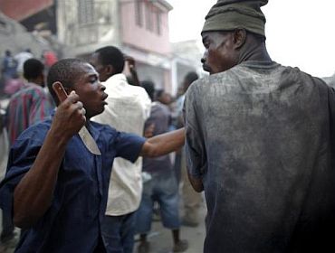 A looter holds a knife as he fights for products in Port-au-Prince