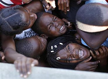 Children cry as the crowd pushes during a food distribution in Cite Soleil, Port-au-Prince