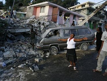 A woman reacts near destroyed buildings after the earthquake devastated Port-au-Prince