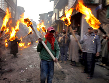 Activists of the Jammu Kashmir Liberation Front hold torches during a procession to mark International Human Rights Day in Srinagar