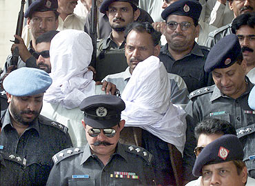 Pakistani police escort Sheikh Omar (L) and Sheikh Adil inside the premises of a judicial court in Karachi