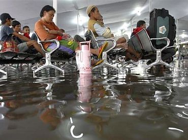 People wait to take a train to their hometowns, in the Senen train station, which was flooded after heavy rains in the morning, in Jakarta September 6, 2010