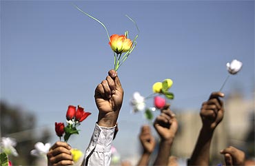 Opposition supporters wave roses during an anti-government protest in Sanaa, Yemen