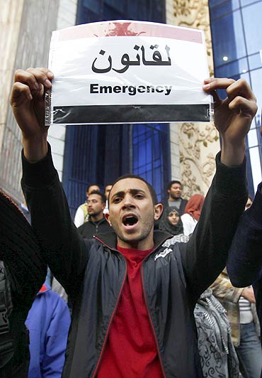 A protester displays a message on a placard of the Egyptian flag during a demonstration