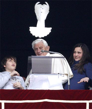 Pope Benedict XVI reacts after he releases a dove from the window of his private apartment