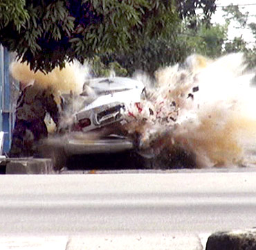 A car bomb explodes as a member of a Thai bomb squad checks it in Narathiwat province