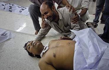 A family member of a victim of a target killing cries next to his body at a morgue in Karachi's Abbasi Shaheed hospital