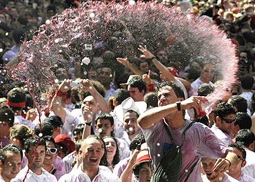 Revellers are sprayed with wine during the start of the San Fermin Festival
