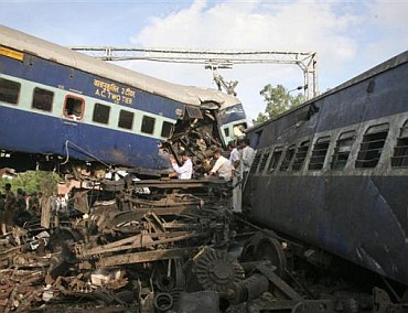 People search the mangled carriages of a derailed Kalka Mail.