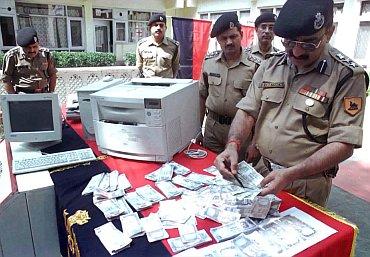 Police testing the authenticity of currency notes seized in a raid