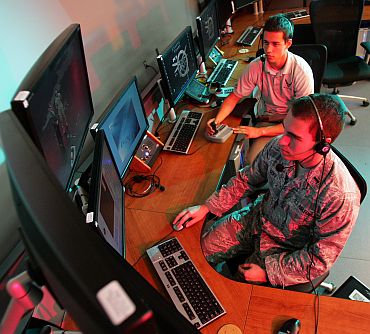 US Air Force First Lieutenant Zachary Goff (foreground), and Chris Allen, a student from Ohio State University, operate the control console to run a test flight of a drone
