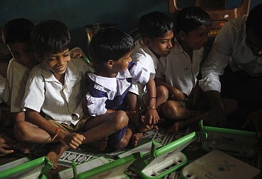 School children use laptops provided to them under the One Laptop Per Child project by a non-governmental organisation