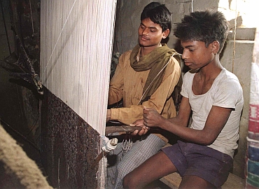 Children weave a carpet in a Balia city factory