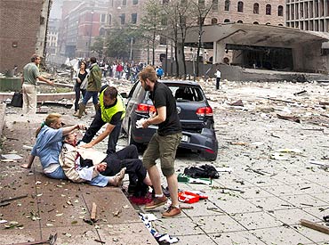 An injured man is attended to at the site of a powerful explosion that rocked central Oslo
