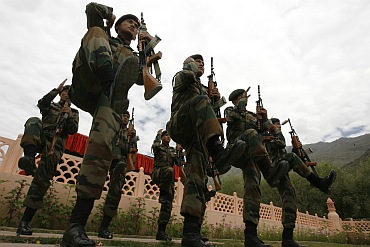 Army soldiers perform during a wreath laying ceremony at the war memorial during Vijay Diwas in Drass