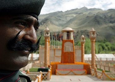 An Indian army soldier stands near the war memorial during a wreath laying ceremony during Vijay Diwas in Drass