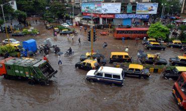 Vehicles make their way through a flooded street in Mumbai Central